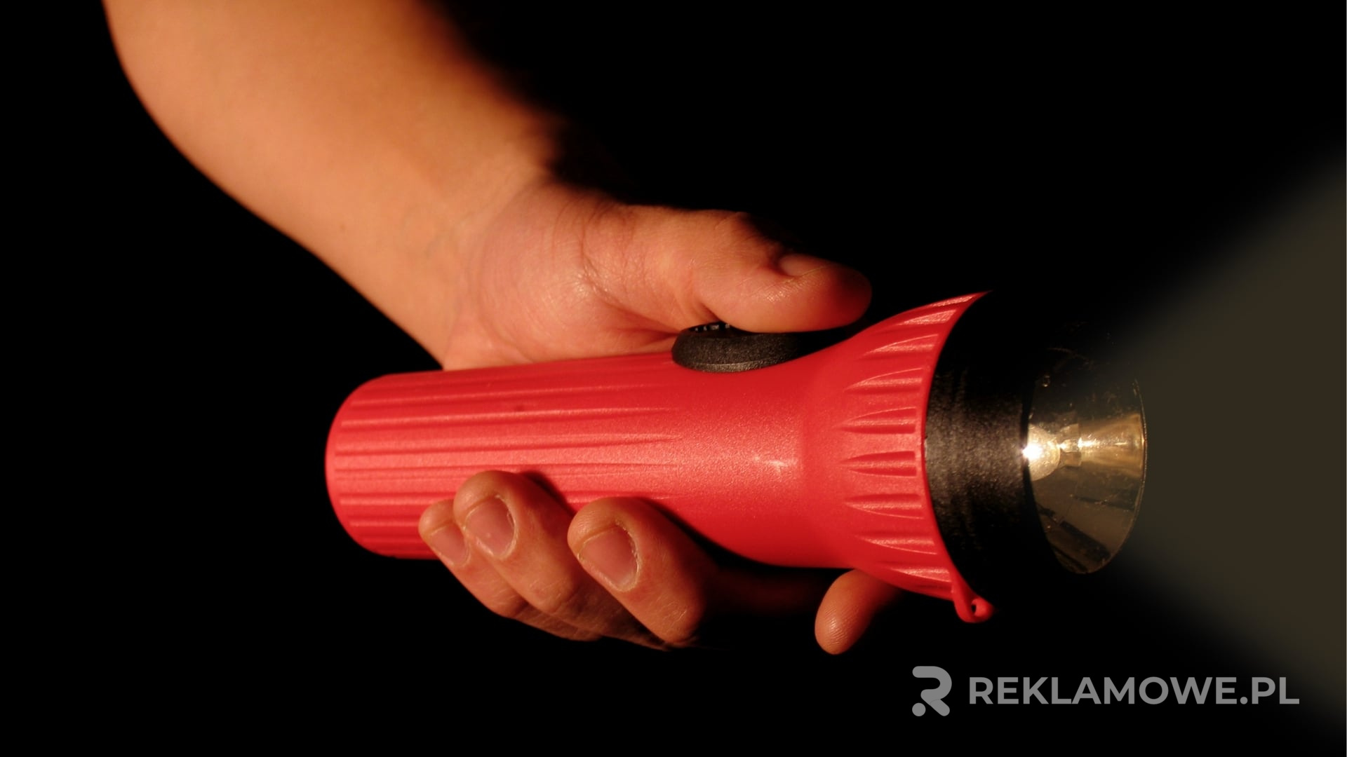 Latarka reklamowa z logo firmy na tle promującym markę